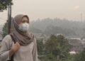 Ilustrasi warga menggunakan masker saat kabut asap akibat kebakaran hutan dan lahan